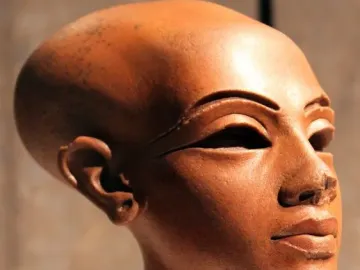 Right three-quarters profile of the Head of a Princess, a polished reddish-brown bust with almond-shaped eyes and full lips.