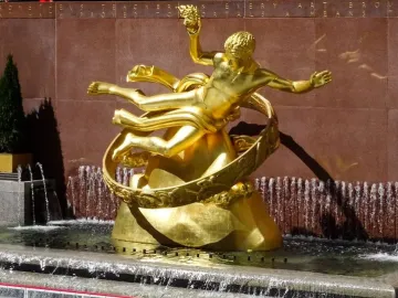 Prometheus, a golden statue in a fountain with water cascading around its base