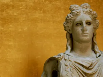 Apollo Barberini marble bust with curly hair and draped shoulders against a golden background.