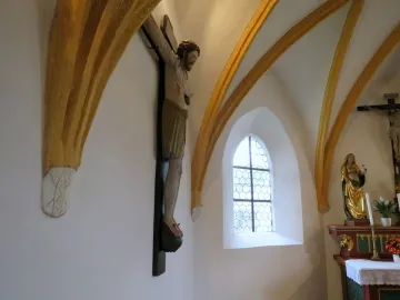 Enghausen Cross wooden crucifix on a white church wall beneath golden arches