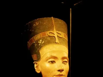 Bust of Nefertiti with a tall decorated crown, broad collar, and one missing eye socket