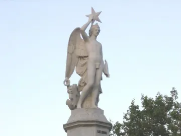 Genio Catalán fountain sculpture of a winged male figure holding a star overhead.