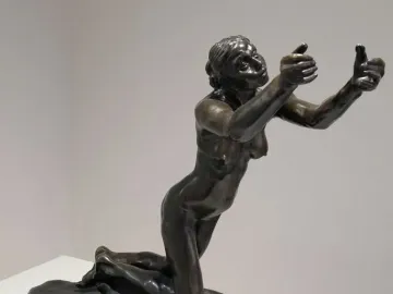 The Implorer bronze sculpture of a kneeling nude woman with her arms raised and palms open.