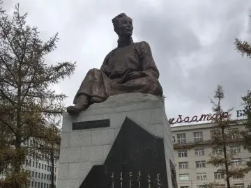 Natsagdorj Monument showing a seated bronze figure on a tiered stone pedestal with inscriptions.