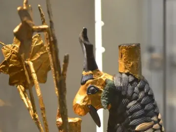 Ram in a Thicket figurine with a golden head, dark horns, and a scale-like body beside a leafy tree.