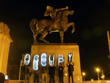 The Bowman equestrian statue atop a pedestal at night, with \