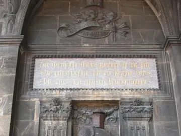 Wehrmann in Eisen, a dark knight statue in full armor holding a sword beneath a stone archway.