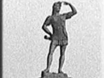 Leif Erikson statue standing on a decorated pedestal with one hand shading his eyes and the other on his hip.