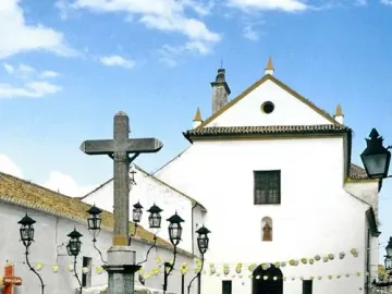 Christ of the Lanterns stone crucifix surrounded by lanterns in a cobblestone square.
