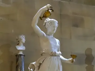 Hebe, a white marble statue of a female figure holding a golden ewer and goblet