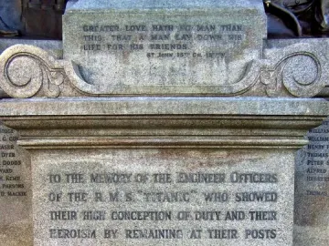 Inscribed stone base of the Titanic Engineers\' Memorial with dedication text and a biblical verse.