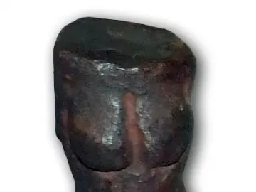 Replica of the Venus of Petrkovice showing a dark prehistoric female torso with pronounced breasts and hips.