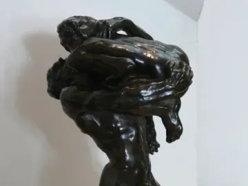 I Am Beautiful bronze sculpture of two intertwined nude figures with a French inscription on the base.