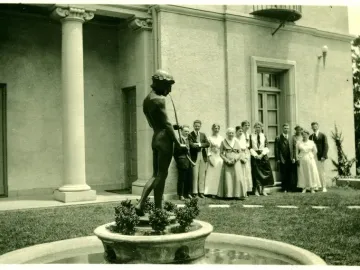 The Spirit of Spanish Music sculpture shows a dark male figure wearing a head wreath and playing a long flute in a fountain basin.