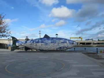 The Big Fish mosaic sculpture on a waterfront promenade beside the river in Belfast.