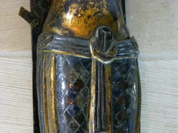 Close-up of the Mindener Cross showing a bronze figure’s diamond-patterned loincloth.