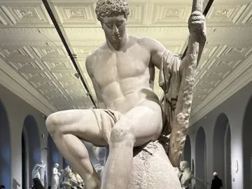 Theseus and the Minotaur marble sculpture by Antonio Canova, showing Theseus seated on the defeated Minotaur in a museum hall.