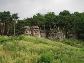 Devil\'s Heads carved into sandstone outcrops on a wooded hillside.