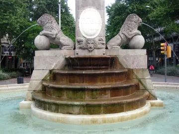Fountain of Hercules with two carved lions on spheres spraying water into a stone basin.