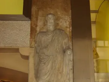 Scior Carera stone relief of a draped male figure with a Latin inscription below.