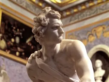 Bernini\'s David sculpture showing a marble figure gripping a sling and looking sharply to the right.