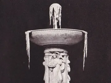 Tiered stone Dupont Circle Fountain with an intricately carved central column and icicles hanging from the upper bowl.