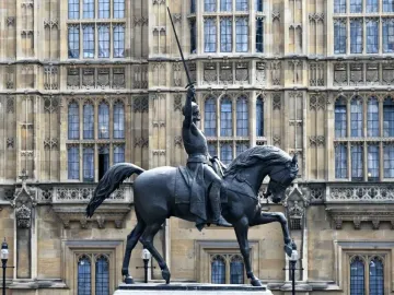 The Richard Coeur de Lion equestrian statue of King Richard I with sword raised in front of the Palace of Westminster.