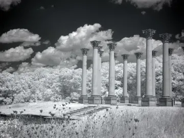 Capitol Columns standing in a grassy field beneath a dramatic cloudy sky.