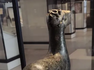Bronze statuette of the Ciervo de Madinat al Zahra with a damaged, mostly missing head and a hollow opening at the top.