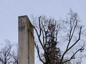 Karl Marx Monument with a dark bust on a pedestal in front of a tall concrete stele.