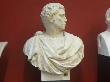 Bust of Brutus with his head turned to the right against a reddish background.