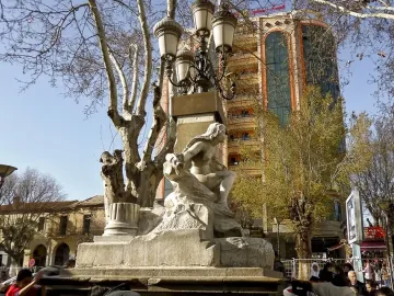 Ain El Fouara Fountain with a reclining female statue and ornate lamppost in Setif.