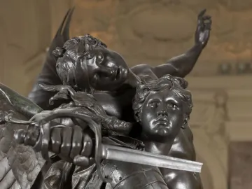 Close-up of Gloria Victis showing a winged bronze figure leaning over a wounded warrior with a sword.
