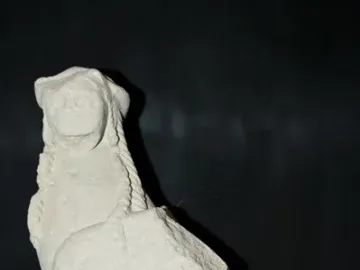 Sphinx of Agost stone sculpture with a human head, wings, and an animal body on a base.
