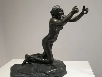 Camille Claudel\'s The Implorer, a dark bronze nude figure kneeling with arms outstretched and head tilted upward.