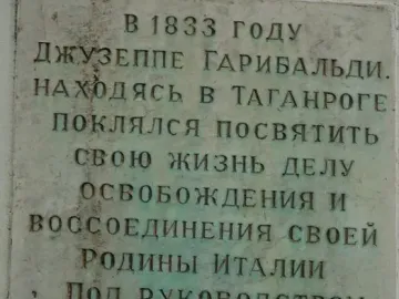 Weathered rectangular plaque with deeply inscribed Cyrillic text on the Garibaldi Monument.