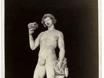 Michelangelo’s Bacchus, a marble statue of a nude male figure holding a goblet and grapes with a small satyr beside him.