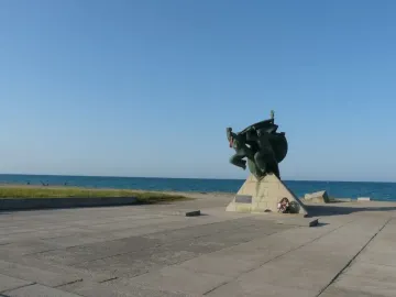 Bronze Monument of Eupatoria Assault on a concrete pedestal near the sea.