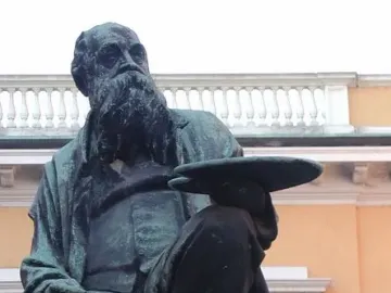 Monument to Mosè Bianchi, a seated bearded statue holding a painter’s palette.
