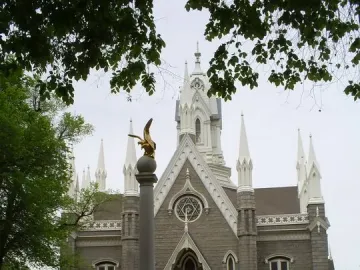 Seagull Monument in front of the Assembly Hall, with a golden bird statue atop a tall column and a stone building behind it.