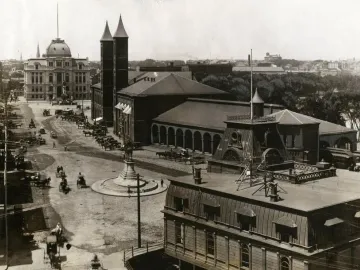 Ambrose Burnside Monument in a historic city square with horse-drawn carriages and brick buildings nearby.