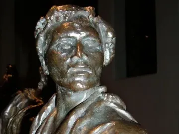 Jean de Fiennes bronze sculpture with a solemn face and heavy folded drapery over the shoulders and chest.