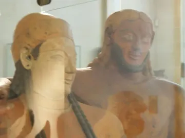 Close-up of the faces of the Sarcophagus of the Spouses, showing a female figure in front of a bearded male figure.