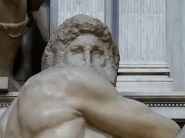Close-up of Michelangelo’s Day, showing the marble figure’s head and muscular upper body with curly hair and deep-set eyes.