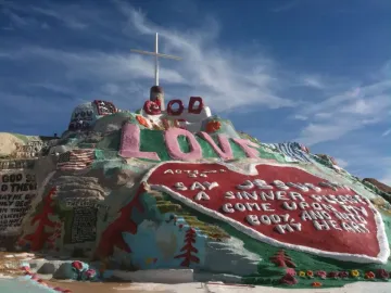 Salvation Mountain with a white cross, pink \