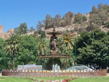 Three Graces Fountain with classical female figures and flowing water in a park