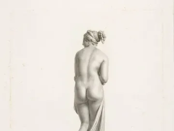Back view of Venus Italica, a classical nude female statue standing on a circular plinth with drapery over one leg.