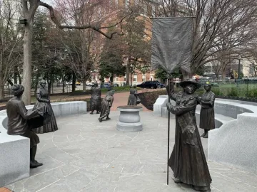 Virginia Women\'s Monument with life-sized metallic statues arranged in a circle, including a central figure holding a Votes for Women banner.