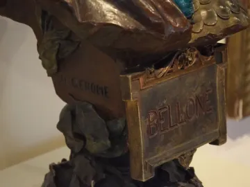 Close-up of the bronze base of Bellone by J.L. Gérôme, showing a BELLONE plaque and carved signature.