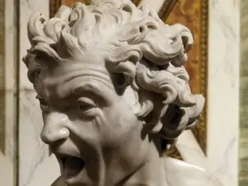 Damned Soul marble bust with a contorted face and open mouth in a scream, set on an ornate pedestal.